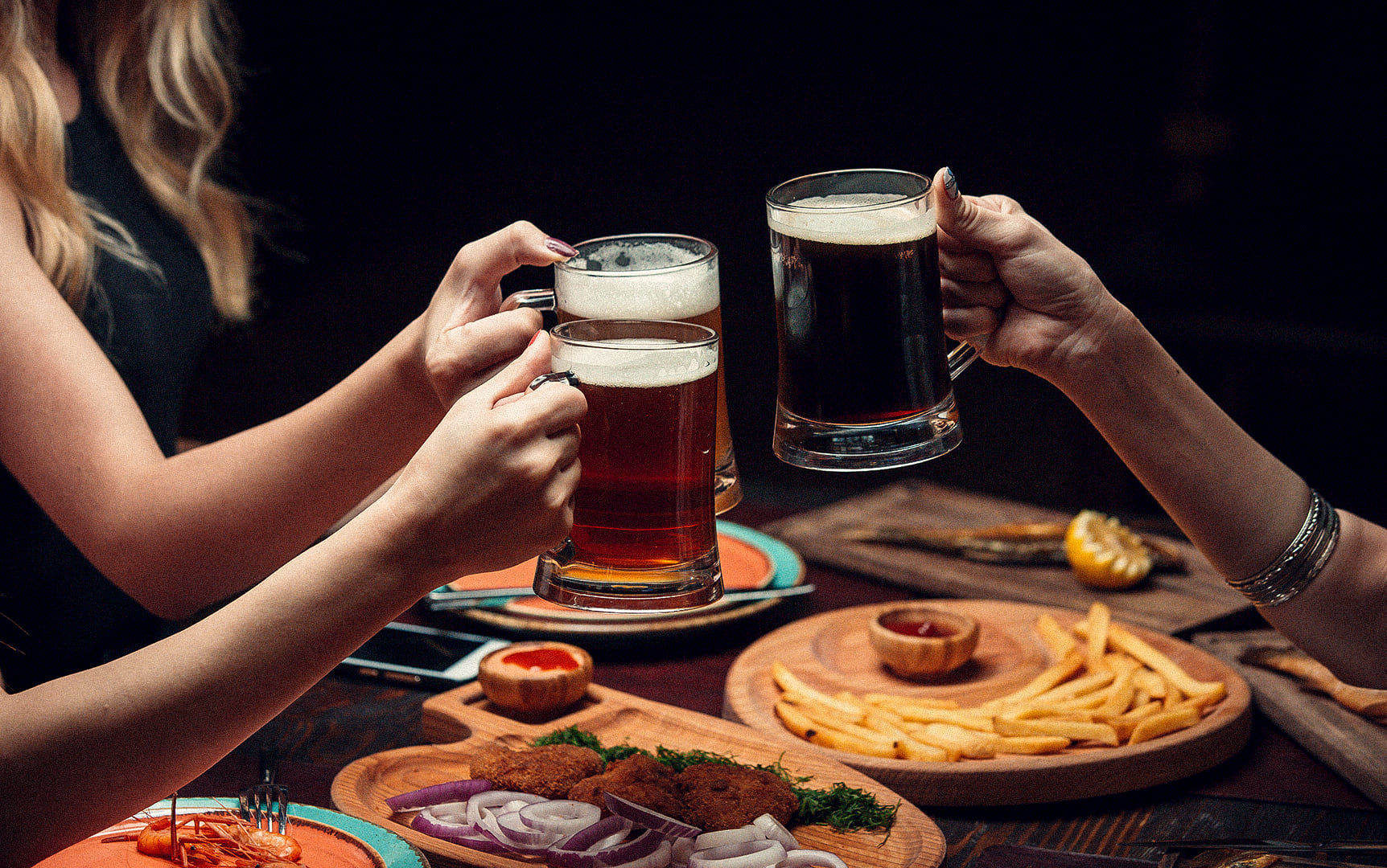 Dinner with friends, warm lighting, hands, and glasses